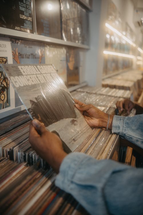 A person holding a record in front of a record store