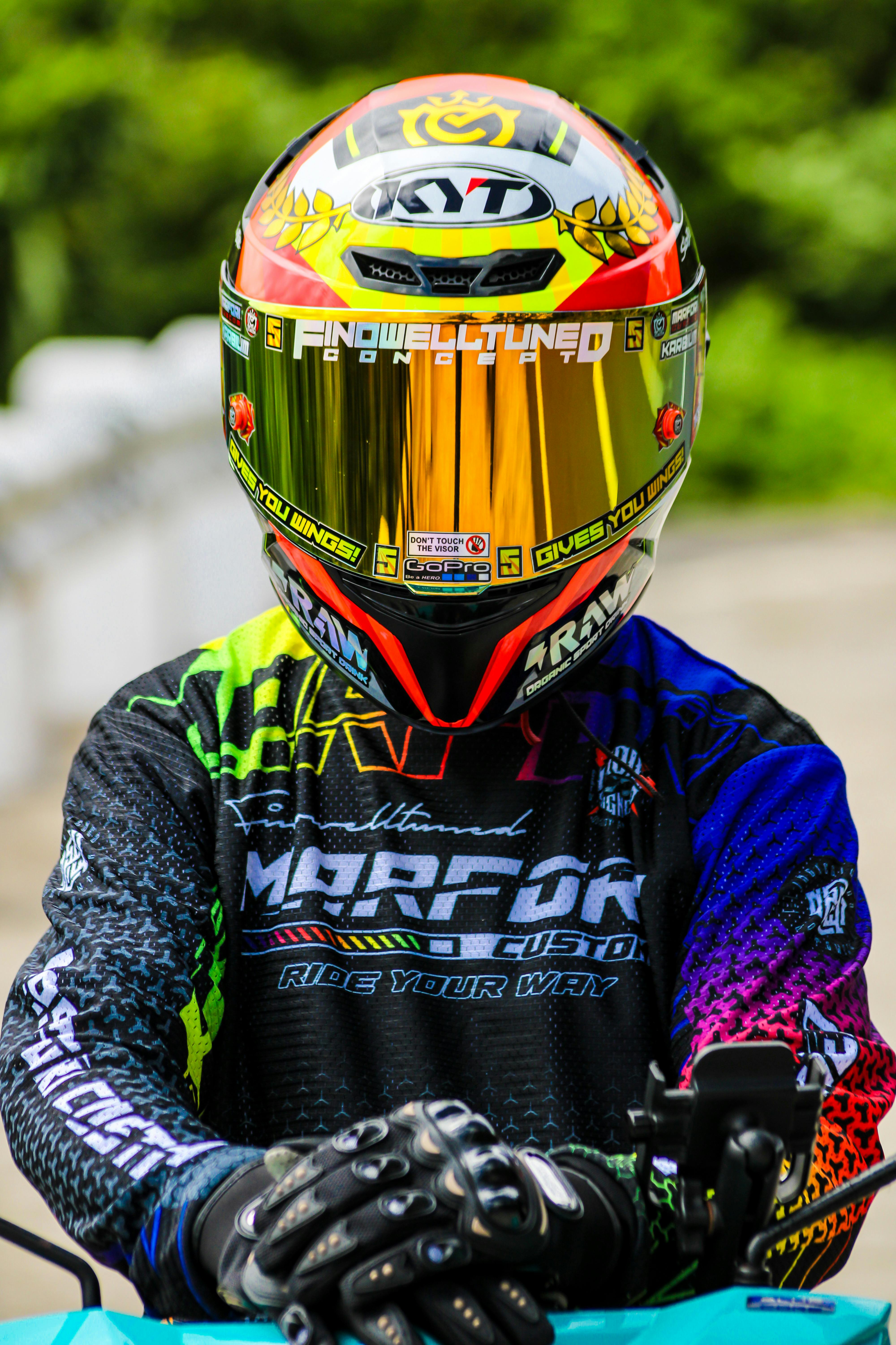 Vibrant motorcyclist with helmet and gear outdoors, promoting safety.