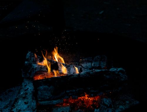 Free Captivating image of a cozy campfire with crackling flames under the night sky, perfect for outdoor themes. Stock Photo