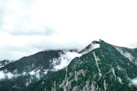 青山郁郁葱葱，部分被云层覆盖，风景宁静