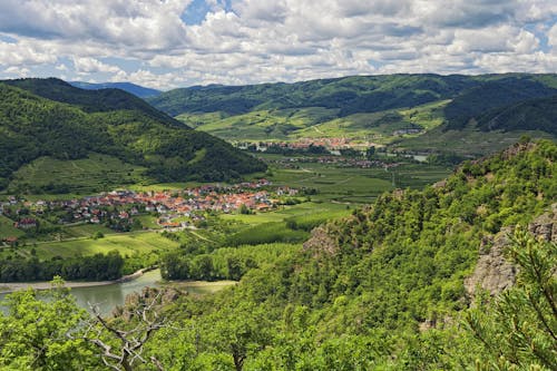 A scenic view of a valley with green hills and trees
