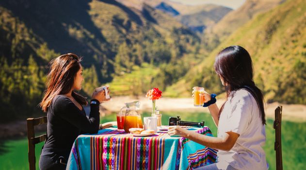 Two women enjoying breakfast with scenic views of Laraos, Peru.
