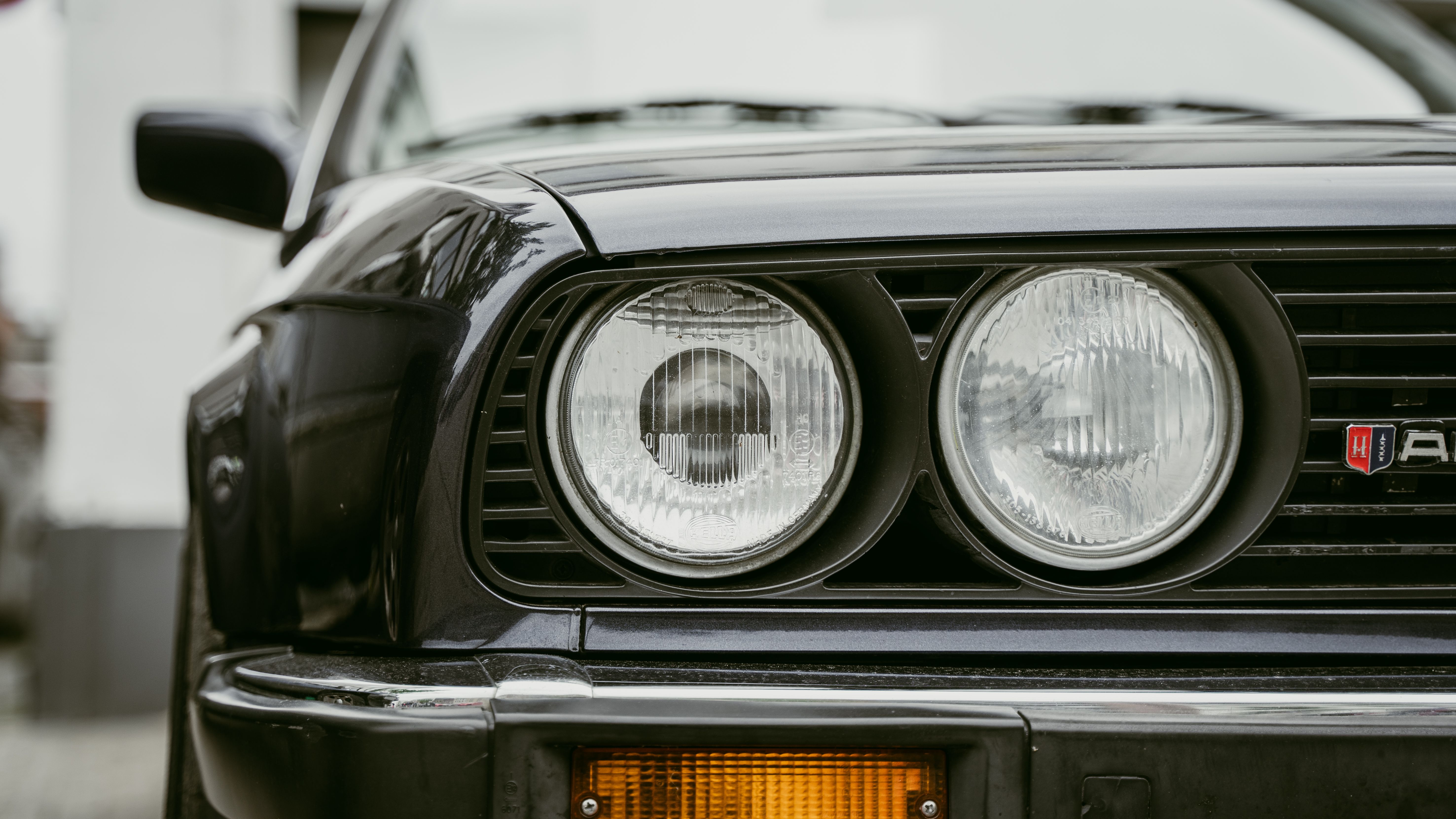 Detailed close-up of vintage BMW E30 car headlights showcasing classic design.