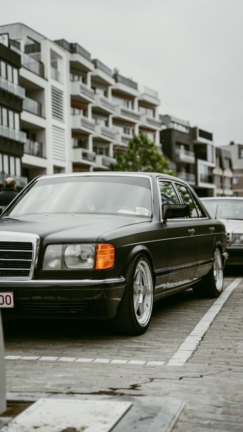 A black mercedes benz parked in front of a building