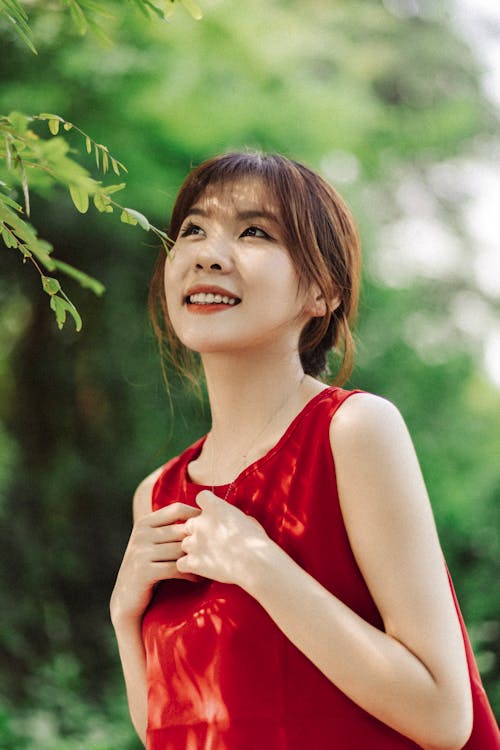 A woman in a red dress smiling and looking at the camera