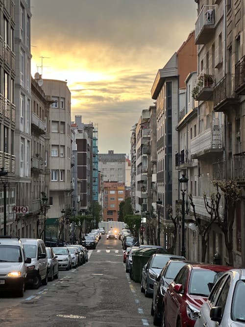 Street with parked cars in the city under the sunset sky, Vigo, Galicia, Spain, April 2023