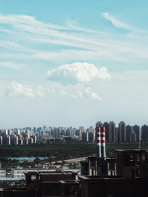 A city skyline with a large factory chimney