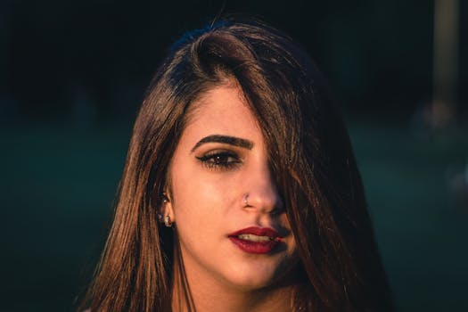 这是一幅女人的特写肖像，深色头发，红唇大胆，在自然光下显得格外醒目