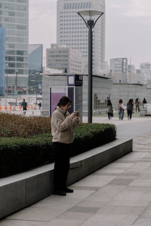 A woman is using her cell phone in a park