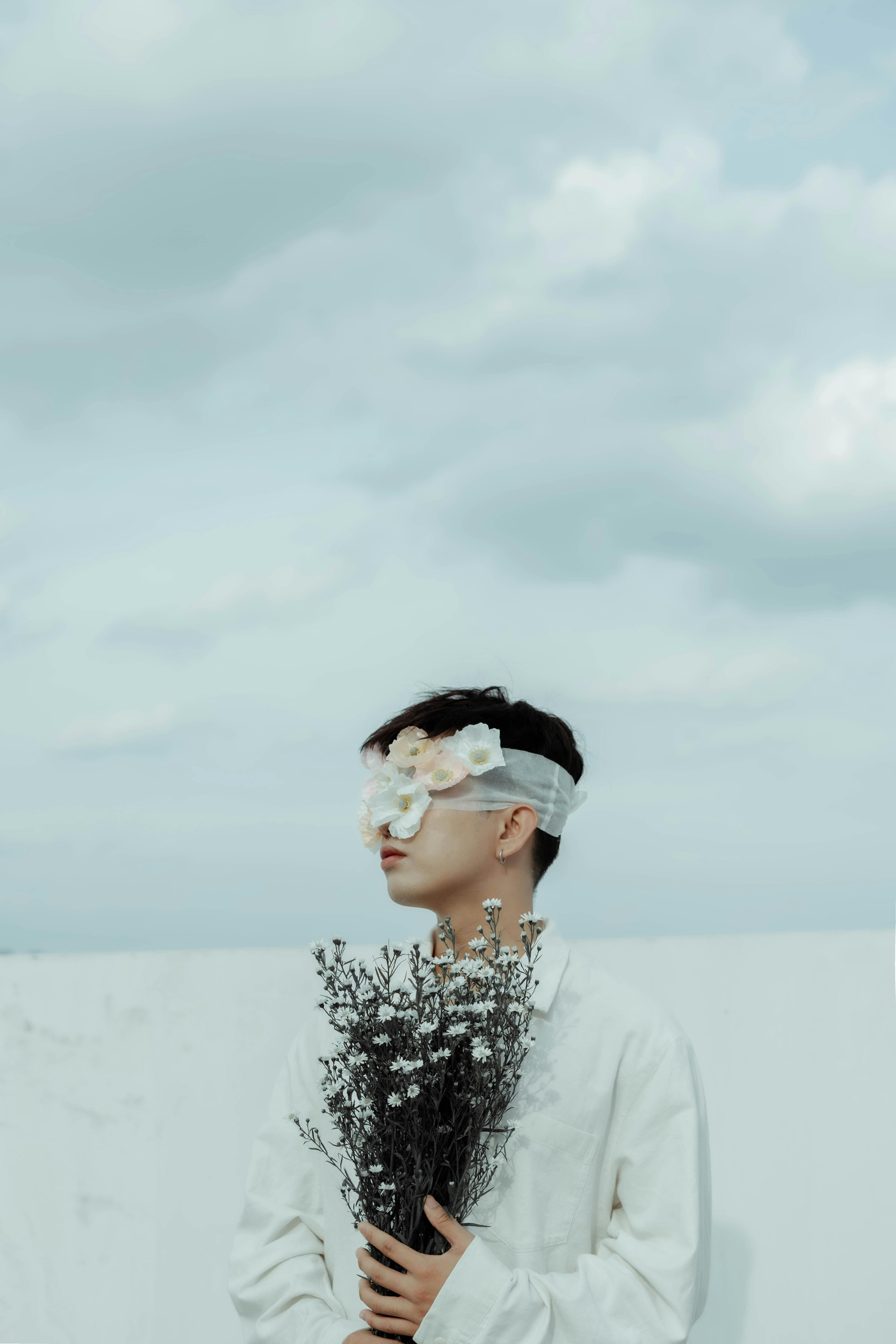 blindfolded man holding flowers