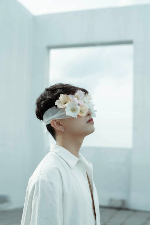 A man with a flower headband on his face