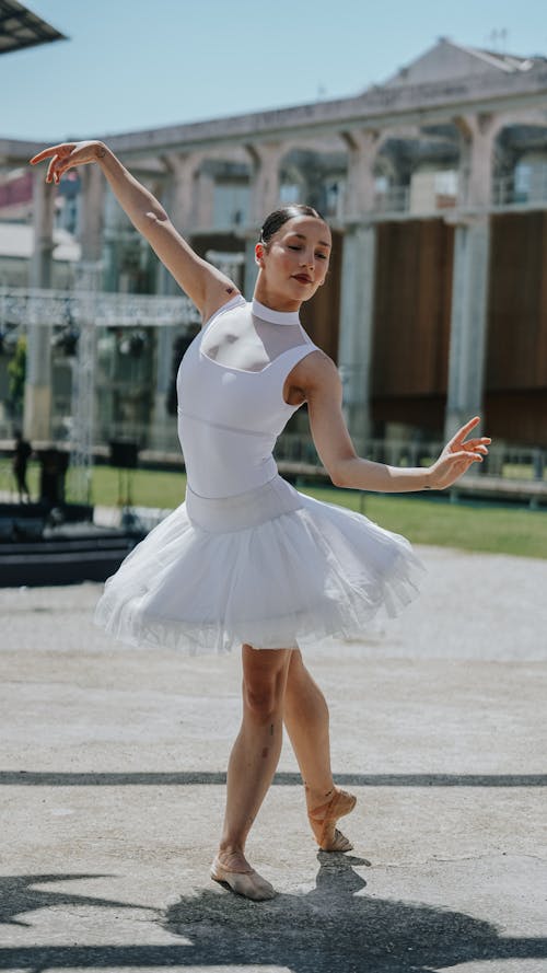 A woman in a white tutu is dancing