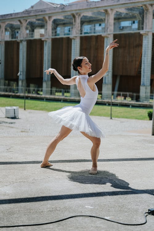 A woman in a white tutu is dancing