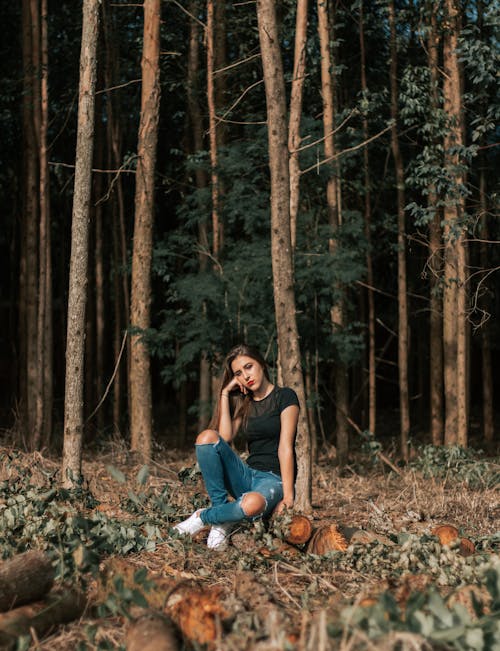 Photo of Woman in the Woods Sitting on Log