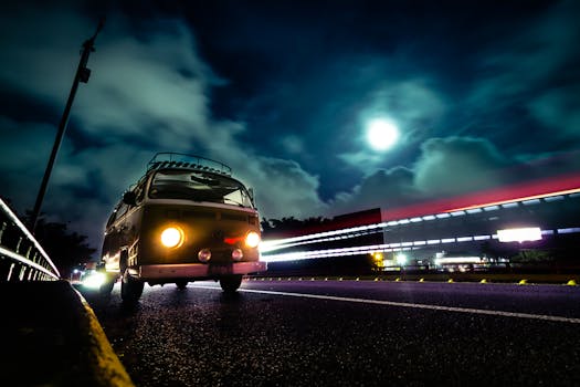 A vintage VW van on a night highway with dramatic light trails and a full moon backdrop.