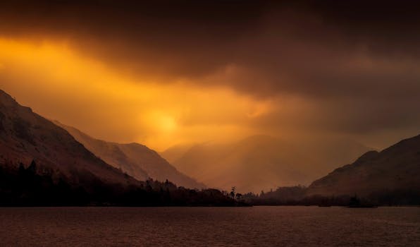 山间宁静的湖泊上，日落景色壮观，山峰轮廓分明