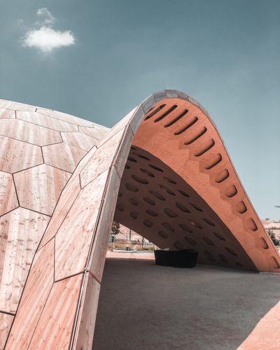 Curved timber pavilion under a clear sky, photo by Benny Merkle on Pexels