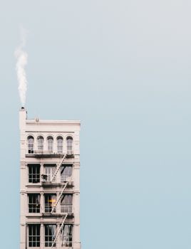 一张拍摄纽约市高层建筑烟囱冒烟的极简主义照片