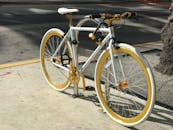 一辆时尚的白金配色自行车停在阳光明媚的街道上，非常适合城市交通主题