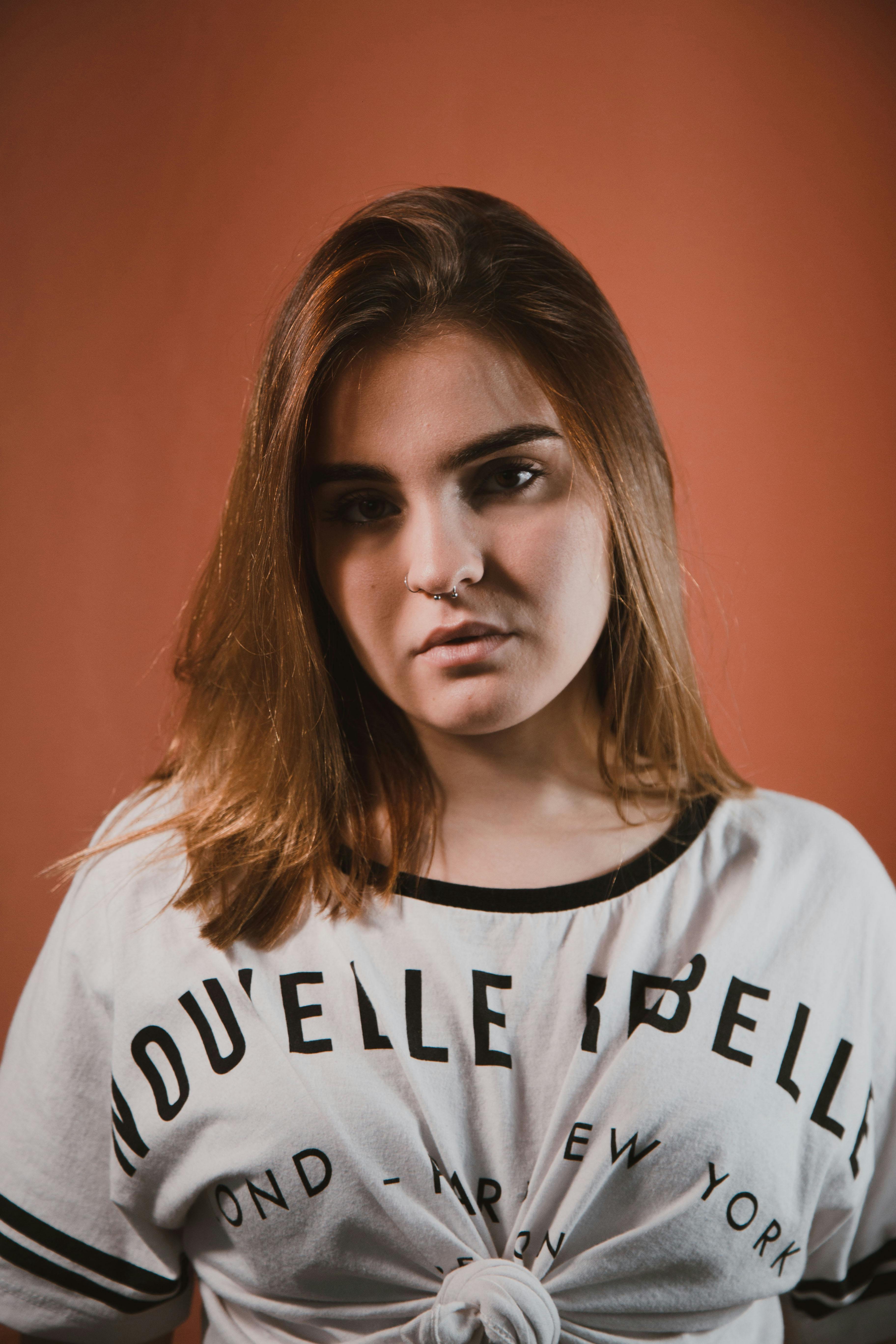 一位年轻女子身着休闲装，在纹理背景前拍摄时尚肖像