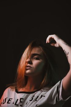 这幅肖像引人注目，画中一位纹身女子神情阴郁，灯光却十分明亮