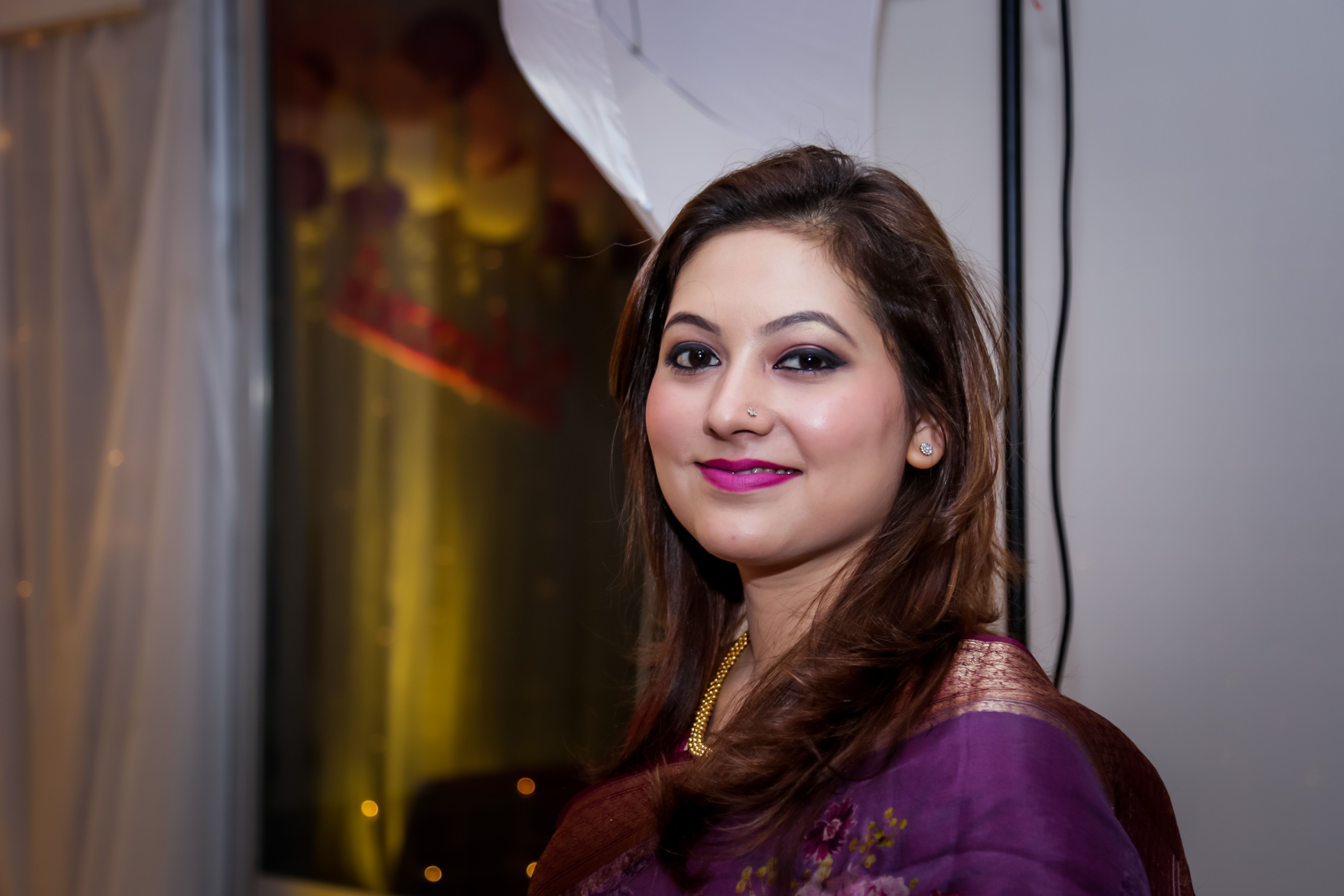 A woman in a purple sari smiling at the camera · Free Stock Photo