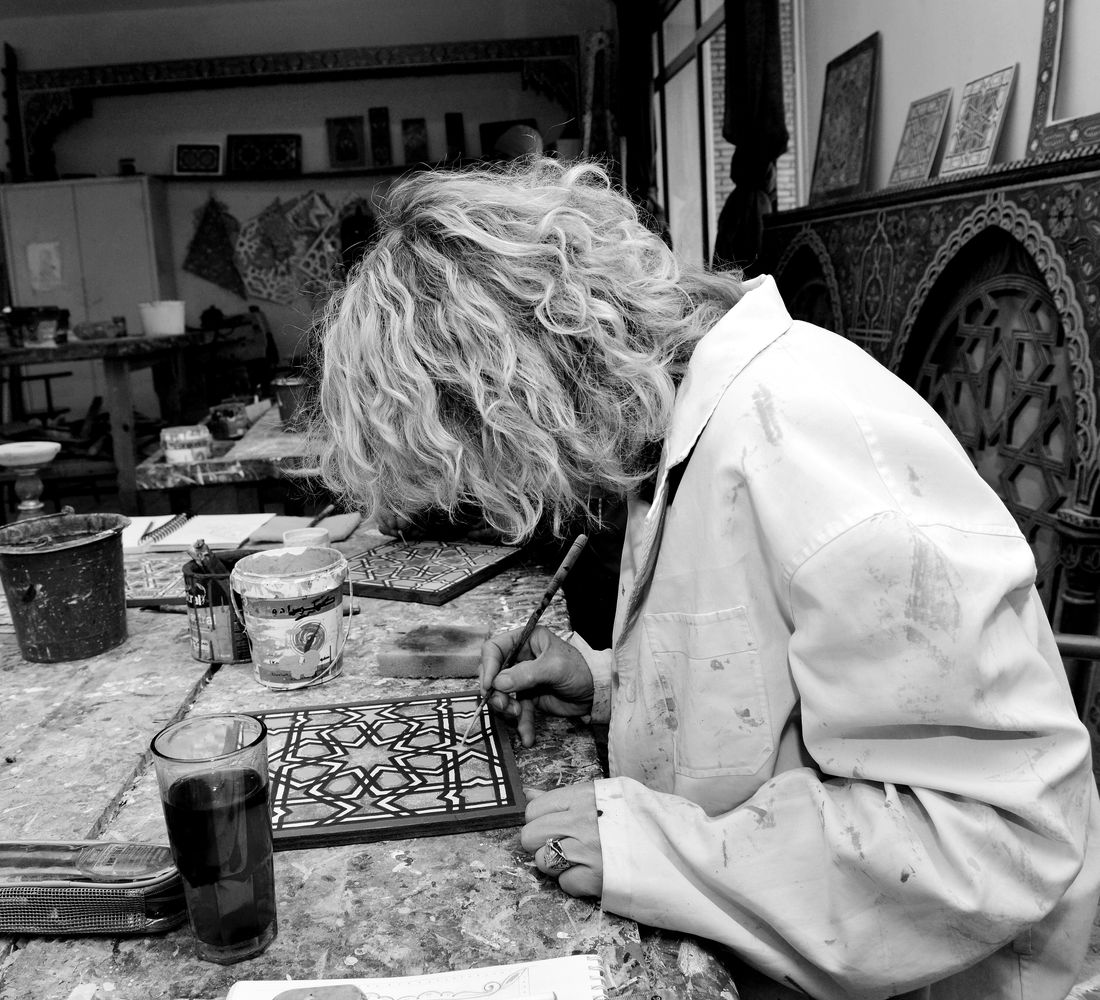 Artisan applique à la main des motifs sur une pièce de carreau