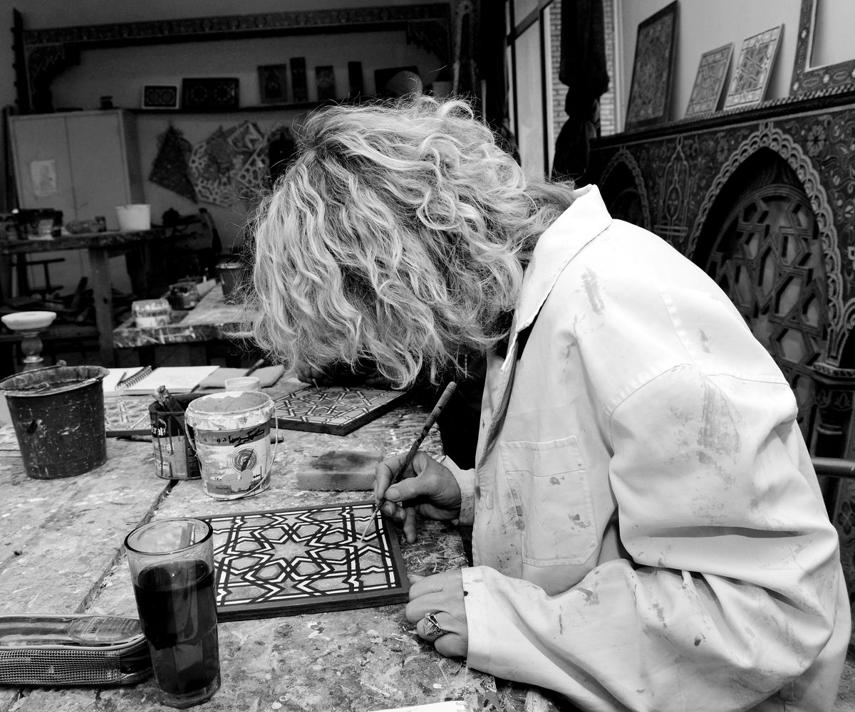 Artisan décorant manuellement un carreau à motifs