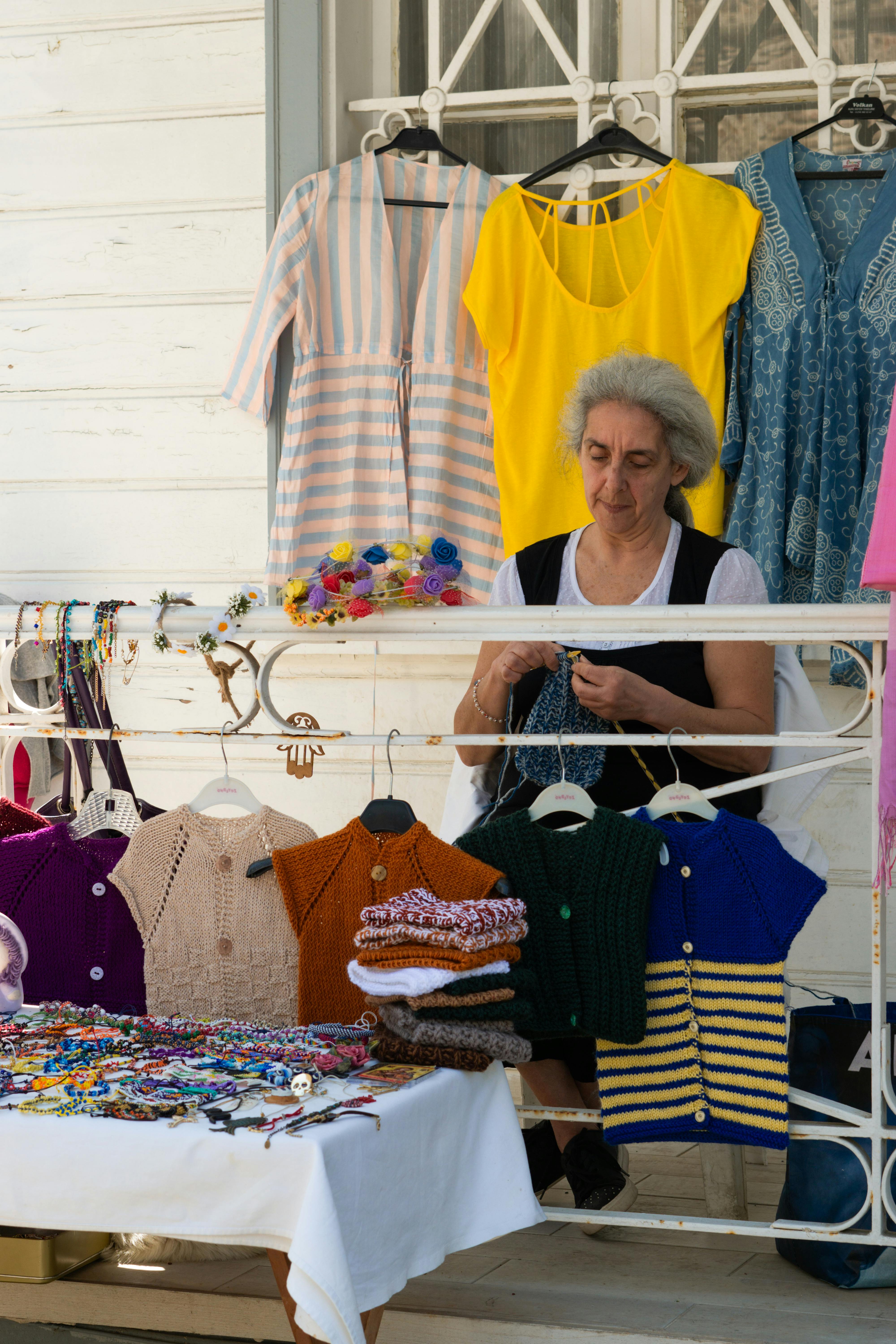 Crochet items displayed with pricing tags on a wooden table