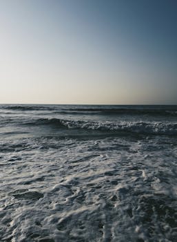 希腊阿吉亚码头日落时分，海景宁静，海浪轻柔，泛起泡沫