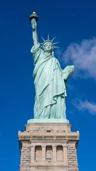 The iconic Statue of Liberty standing tall against a vibrant blue sky in New York, USA.