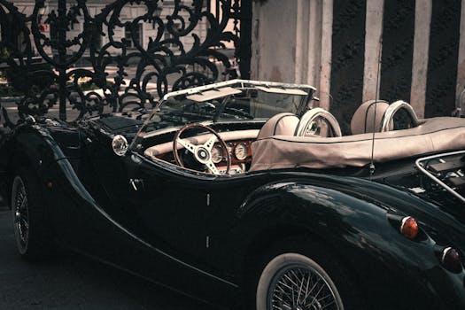 Classic roadster car parked by an intricate gate in Moscow, showcasing retro style and elegance.