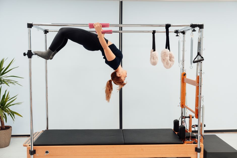 Cours de Pilates collectif dans un studio lumineux avec équipements spécialisés