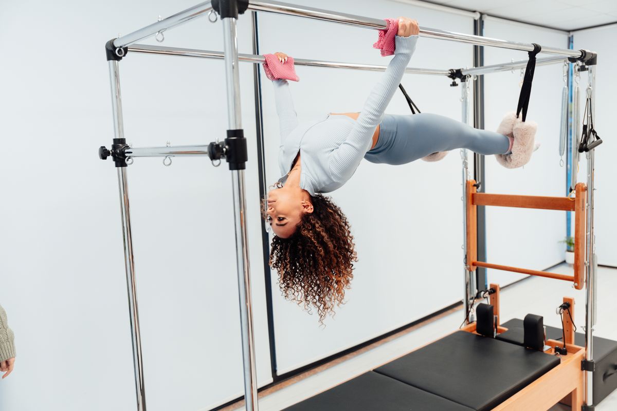 Woman performing a controlled Pilates exercise in a studio