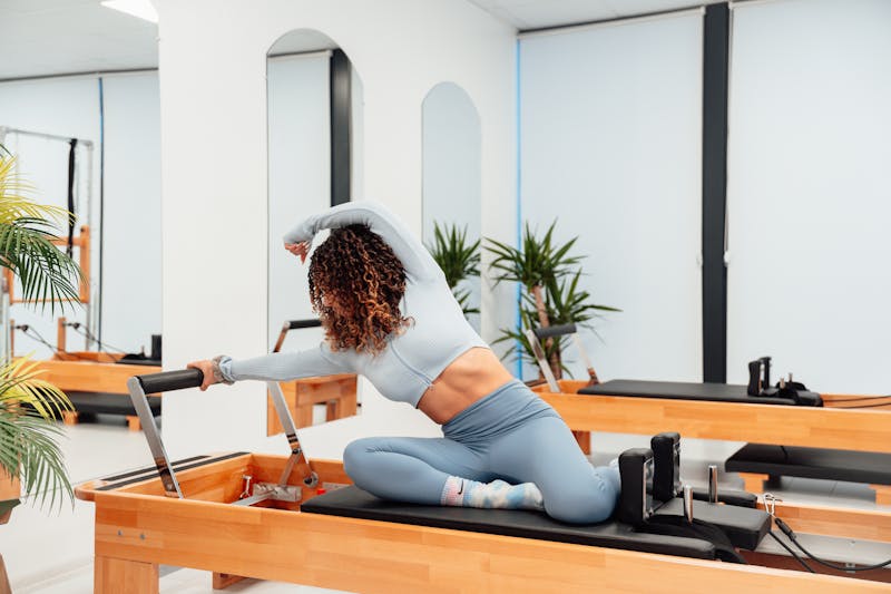 Femme pratiquant le Pilates sur Reformer