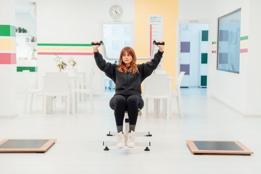 A woman exercising with weights indoors at a fitness facility in Yalova, Türkiye.