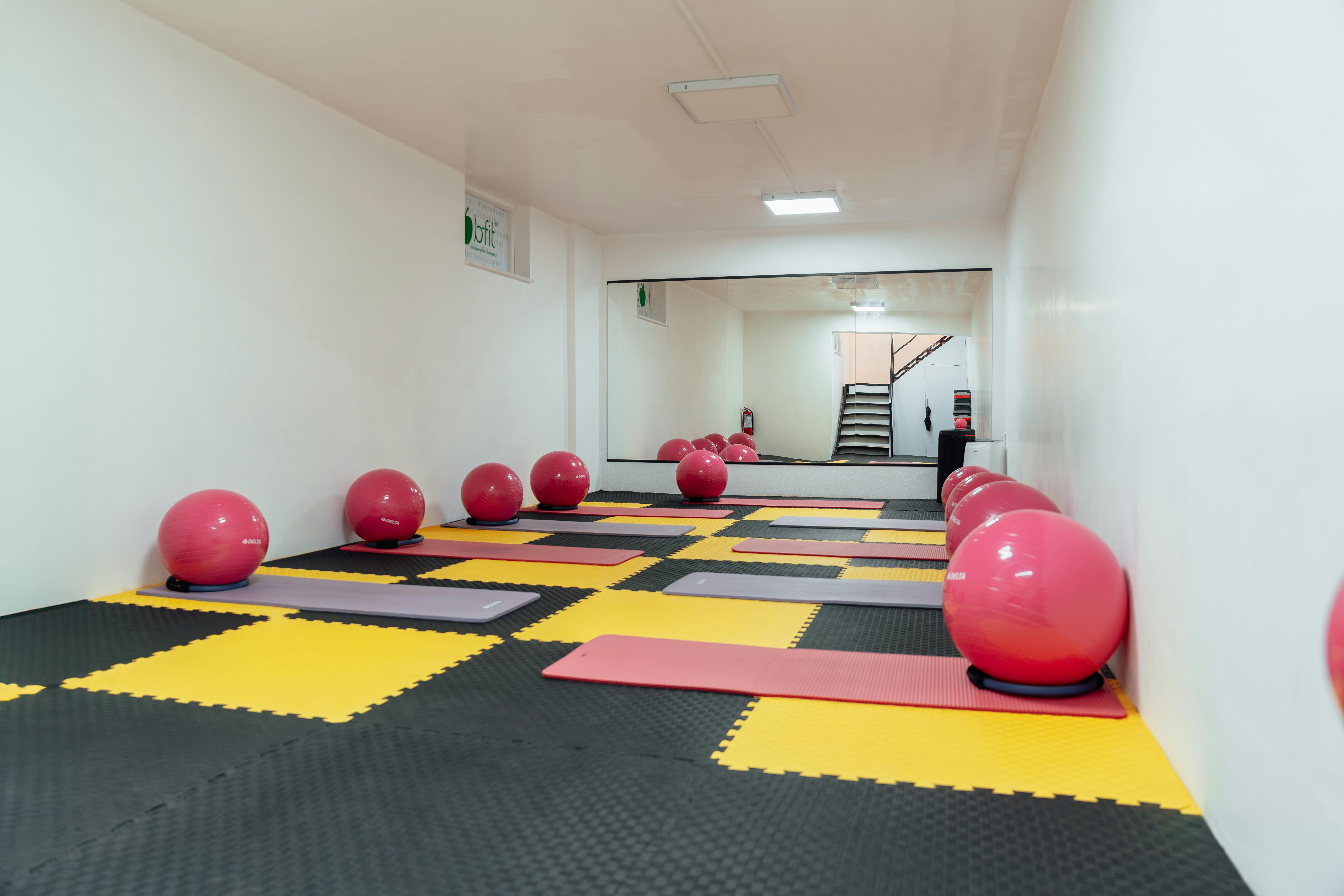 groveland fl commercial property insurance - A modern gym interior featuring pink exercise balls and yellow mats, ideal for fitness classes.