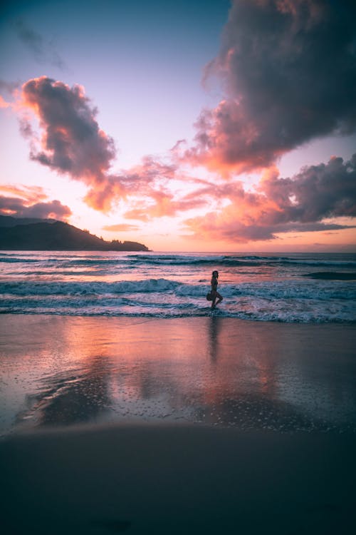 Photo of Woman Walking on Seashore
