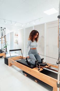 A young woman engaged in a pilates workout in a modern studio setting.