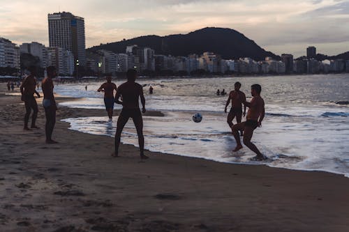 Mężczyźni Grają W Piłkę Nad Brzegiem Morza