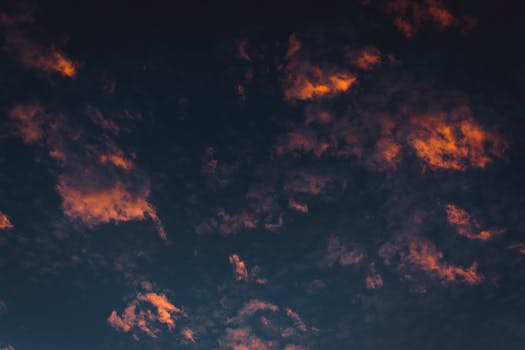 Vibrant and dramatic view of the evening sky with orange-tinted clouds at sunset.
