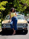 阳光明媚的户外，一位时尚女士优雅地靠在一辆老爷车上，散发着时尚气息