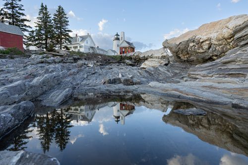 Free Pemaquid Point Lighthouse reflecting in rock pools, capturing serene coastal beauty. Stock Photo