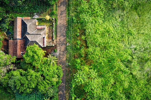 Aerial view of a house surrounded by lush greenery and countryside in West Java, Indonesia.