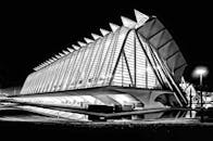 一幅黑白图像以戏剧性的方式展现了未来派建筑，灯光与反光引人注目