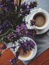 木桌上，咖啡杯旁的薰衣草花自上而下映入眼帘，营造出舒适的氛围