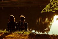 夕阳下，一对夫妇坐在湖边，享受着金色的宁静