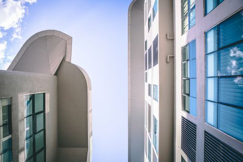 Free Low angle view of modern buildings with glass facades reflecting the sky. Stock Photo