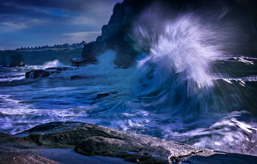Free Powerful ocean waves crash against rocky cliffs, showcasing the dramatic beauty of nature. Stock Photo