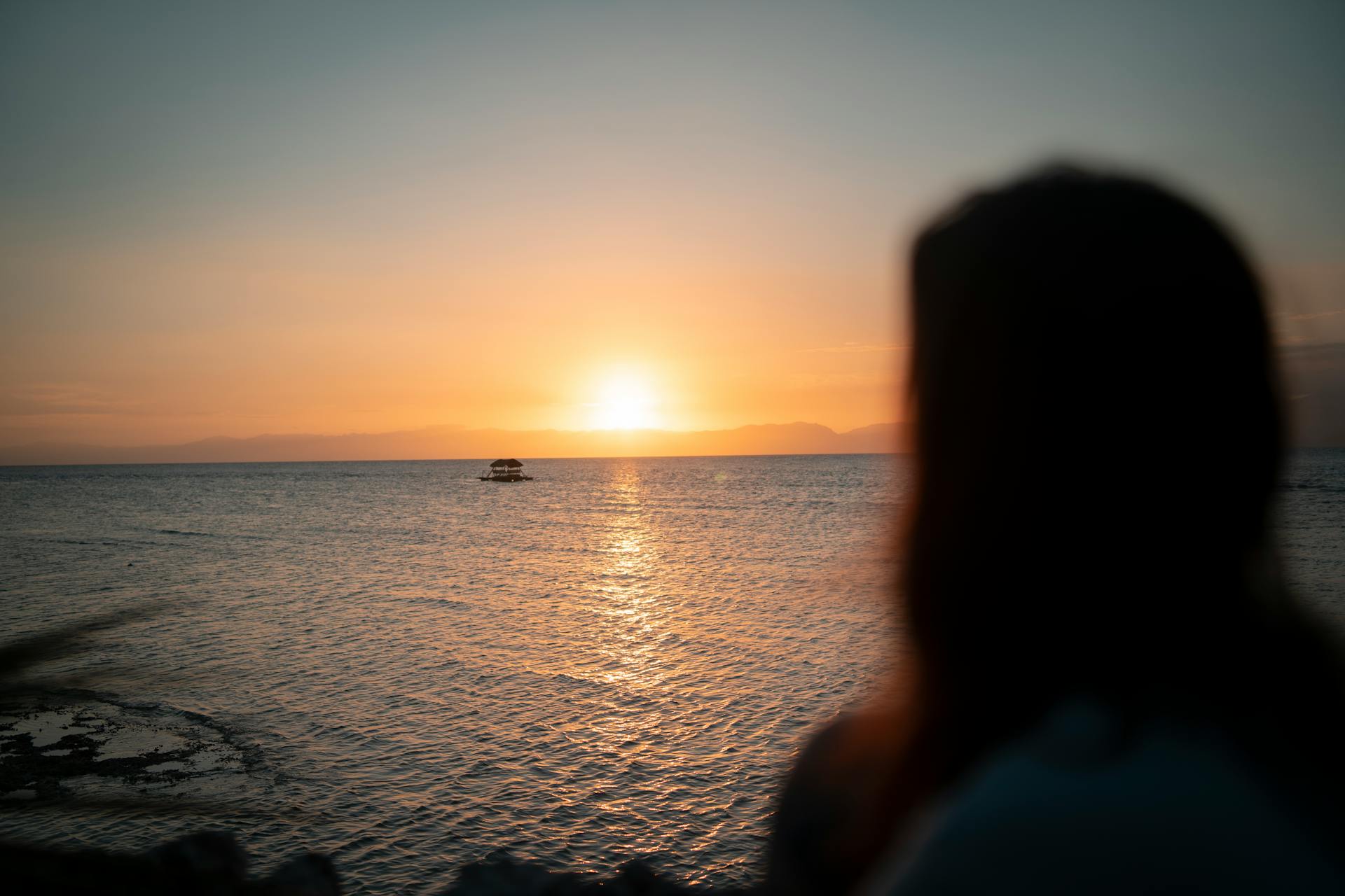 Beautiful sunset view with silhouette, capturing the serene ambiance of a Philippine beach scene.